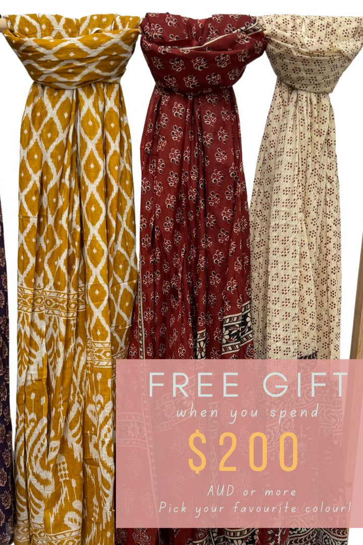 Four patterned scarves on a rack with a promotional message for a free gift offer.