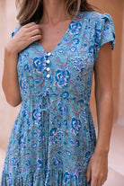 close up of woman wearing a aqua blue floral dress with button down front