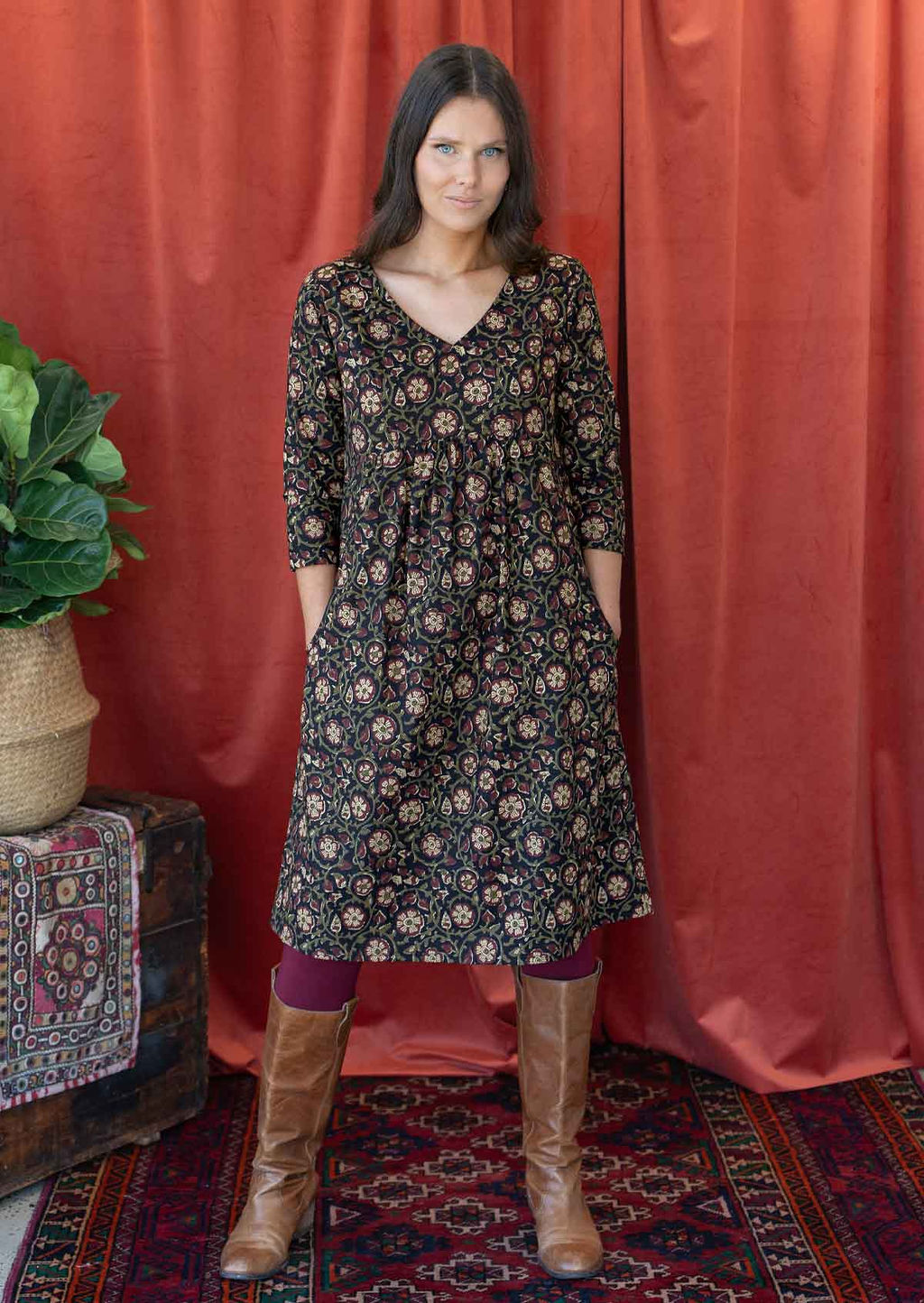 Model poses in over the knee length black based floral print cotton dress with 3/4 sleeves