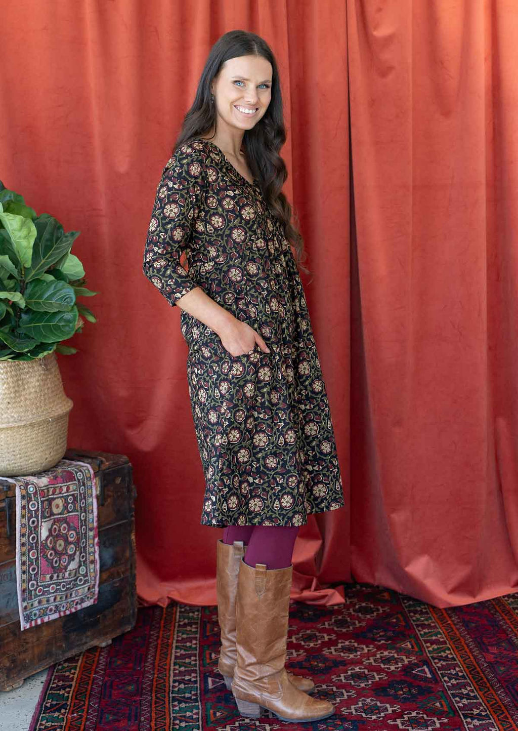Woman wears cotton 3/4 sleeve relaxed fit dress paired with maroon leggings and boots