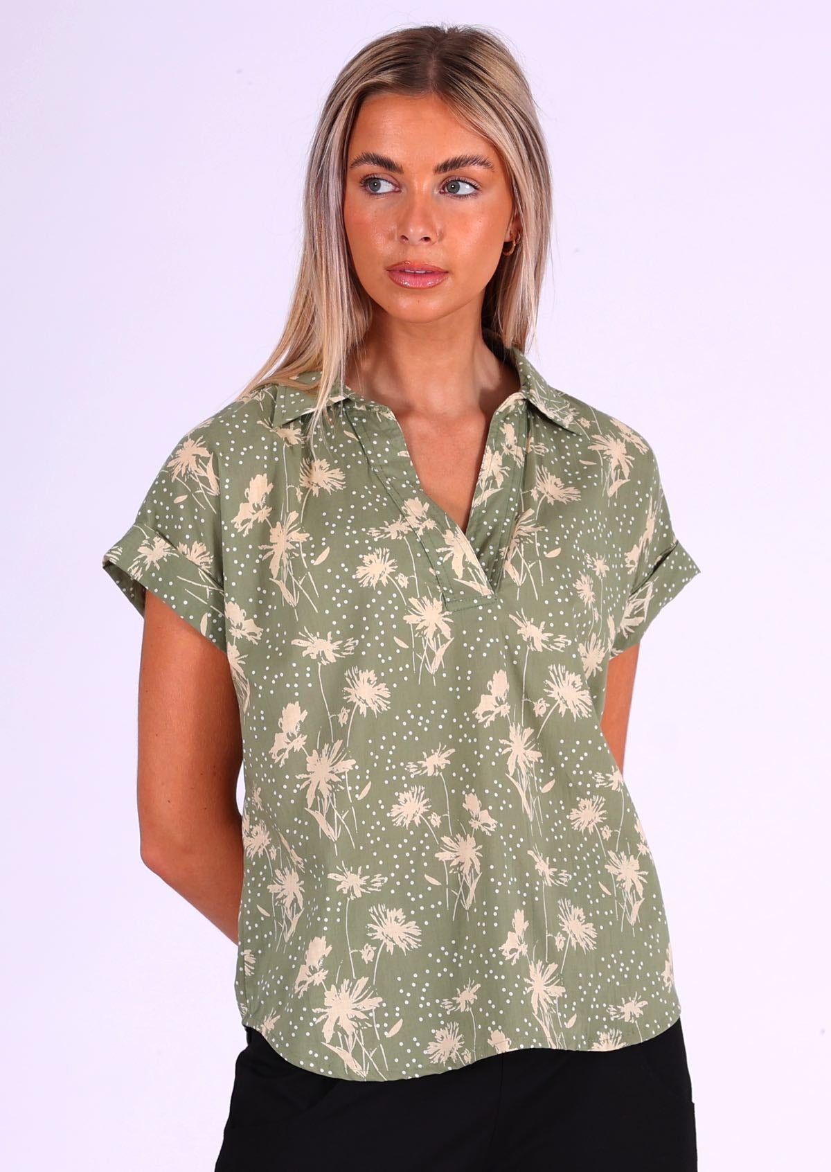 Woman wears cotton loose fit top with short sleeves with a rolled cuff, a V-neckline and a collar