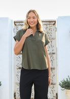 Woman wears 100% cotton shirt style relaxed fit olive green top with structured collar, short sleeves and V neckline