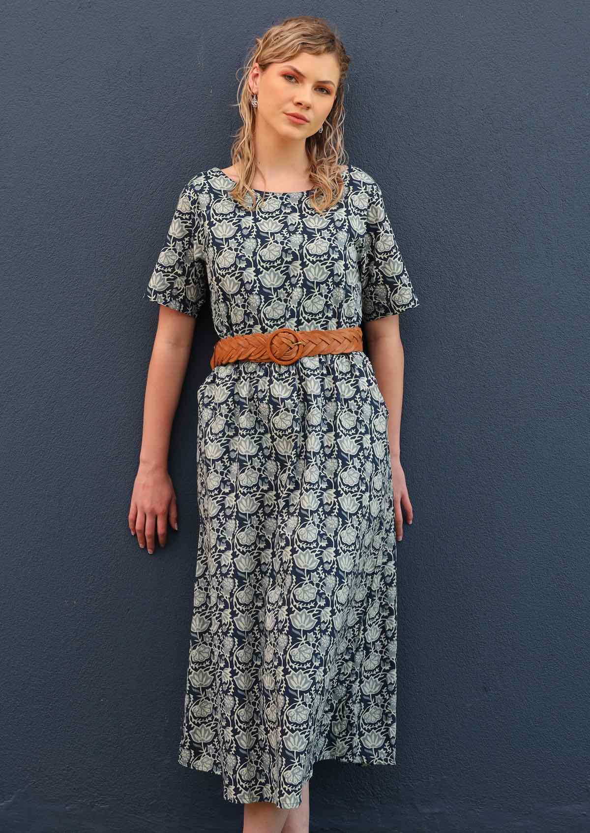 Model pairs loose fitting dress with a belt to cinch the waist.