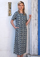 Model is wearing a loose fitting dress that ends mid calf.