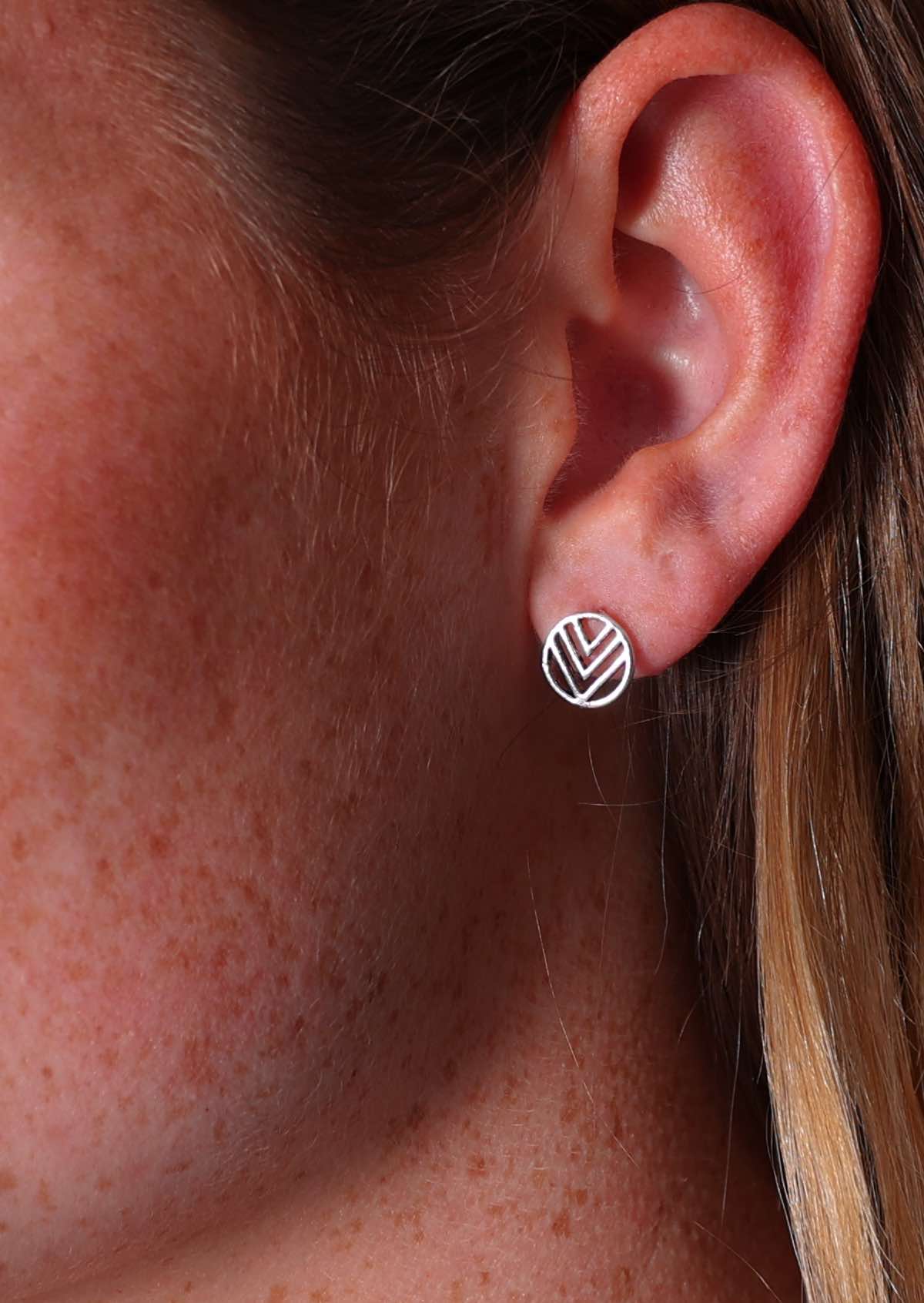 Close up of sterling silver stud earring cutout circle with three V's inside