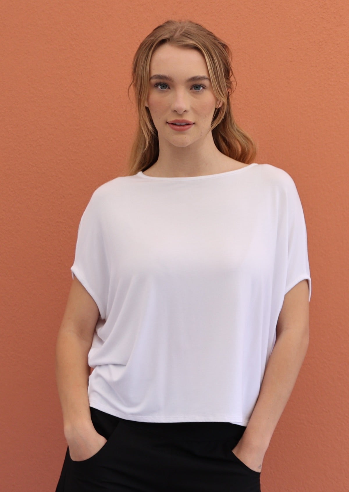 Woman wears soft stretch rayon white batwing t-shirt paired with black pants