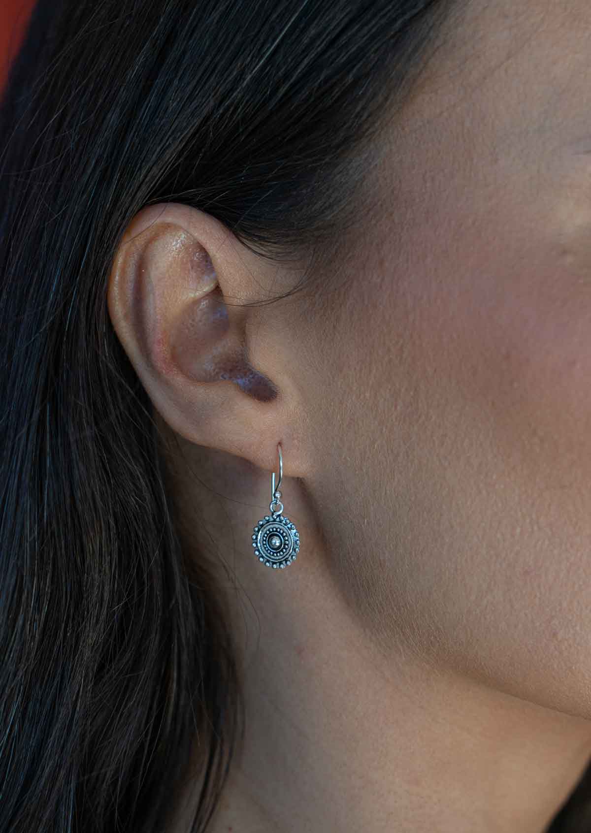 sweet sterling silver small charm disc earrings on woman's ear