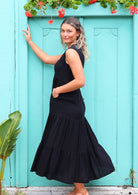 Woman in Black Rayon Maxi Dress with hand in pockets full skirt flaring out