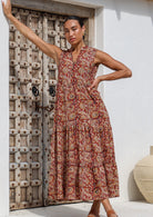 Model poses in 100% cotton sleeveless boho tiered maxi dress in gorgeous earthy floral print.