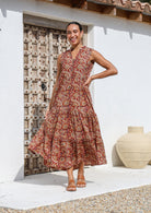 Gorgeous floral printed sleeveless maxi dress in warm earthy tones with buttoned bodice and pockets .