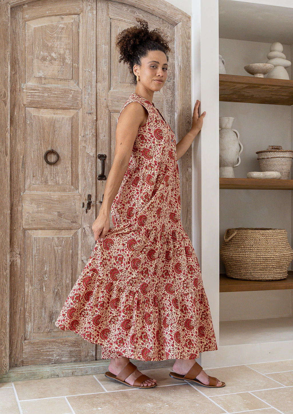 Model stands sideways wearing a 100% cotton 3 tiered maxi dress with flowy skirt, 3/4 sleeves, buttoned bodice and pockets.