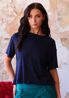 woman in navy blue loose fit t-shirt  over teal corduroy pants