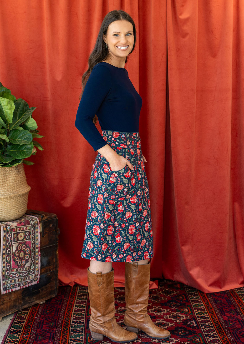 Model wears cotton floral print knee length pencil skirt with side zip and pockets, paired with a dark blue stretch rayon top