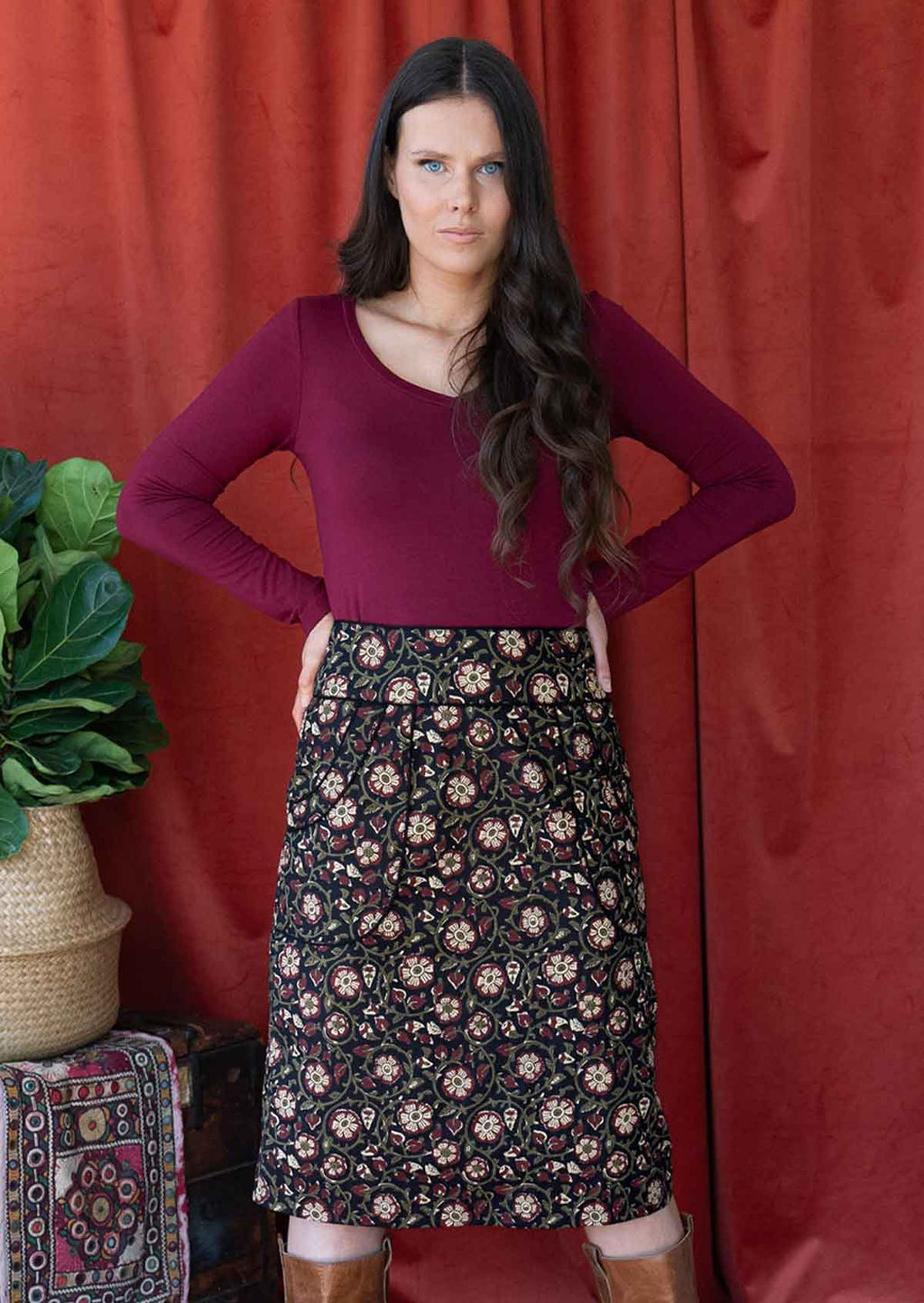 Woman wears black based over the knee length cotton pencil skirt with high waistband and piped details around pockets