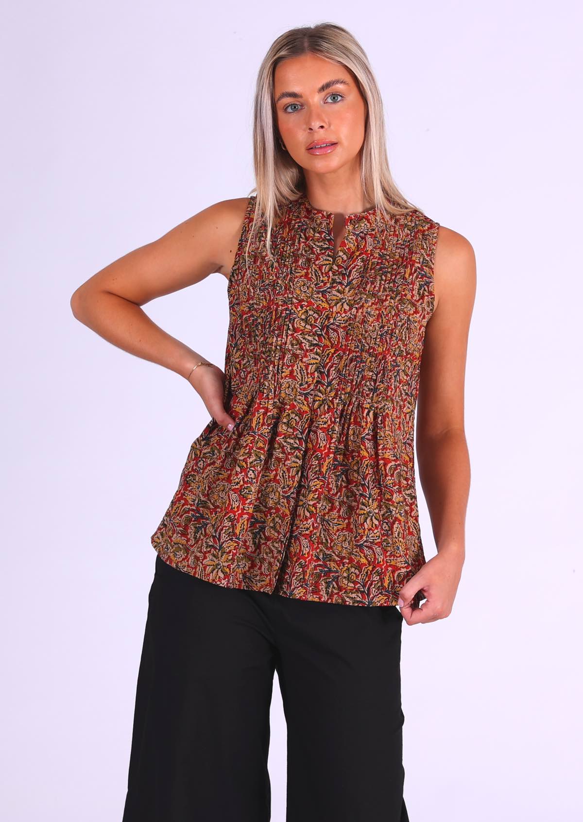 Model wears cotton sleeveless blouse that covers the hips, in Indian floral print in warm colours