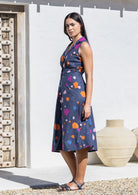 Model standing in sun wears A line, button through cotton dress with collar and gathers under the bust.