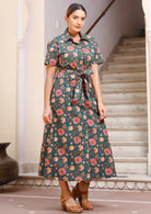 Model wears button through shirt style dress with short sleeves and detachable waist tie.