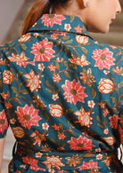 100% cotton, pinkish red, cream and orange floral printed green dress with shirt style sleeve, collar and waist tie.