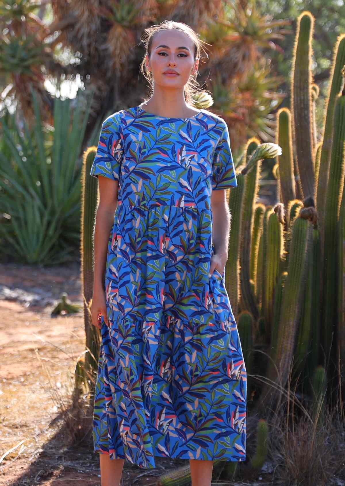 Model wears cotton midi length relaxed fit dress with high round neckline and short sleeves