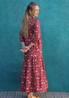 Woman standing with back to camera in cotton maxi dress with a tiered skirt and 3/4 sleeves