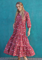 Woman spins in cotton maxi dress with voluminous tiered skirt, 3/4 sleeves and V-neckline