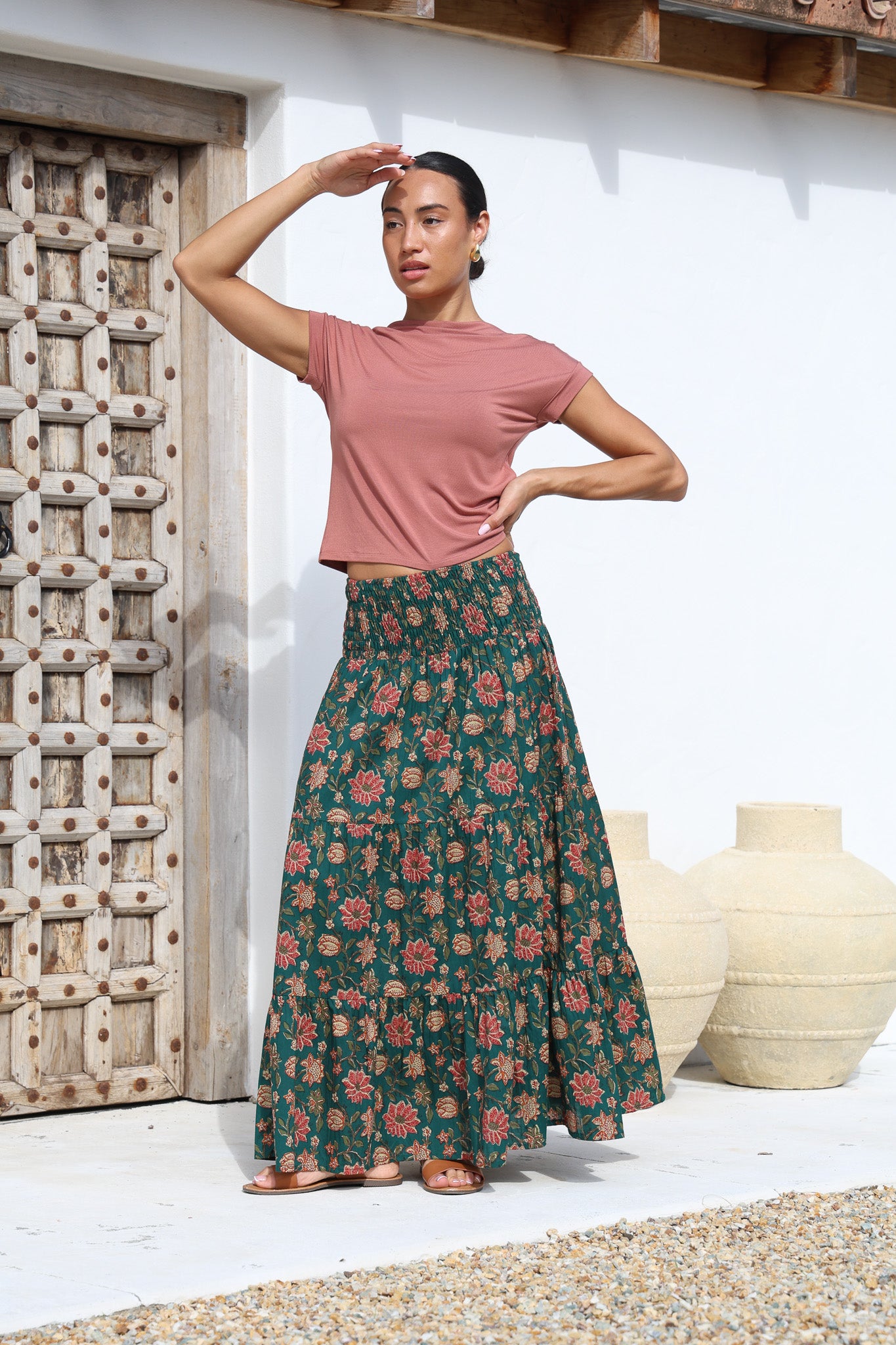 Model wears floral printed, cotton tiered maxi skirt with wide elasticated waistband. Paired with wide neck dusty rose top.