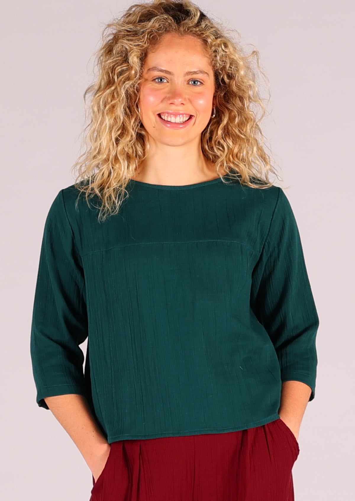 Model wears deep teal double cotton top with 3/4 sleeves and high round neckline