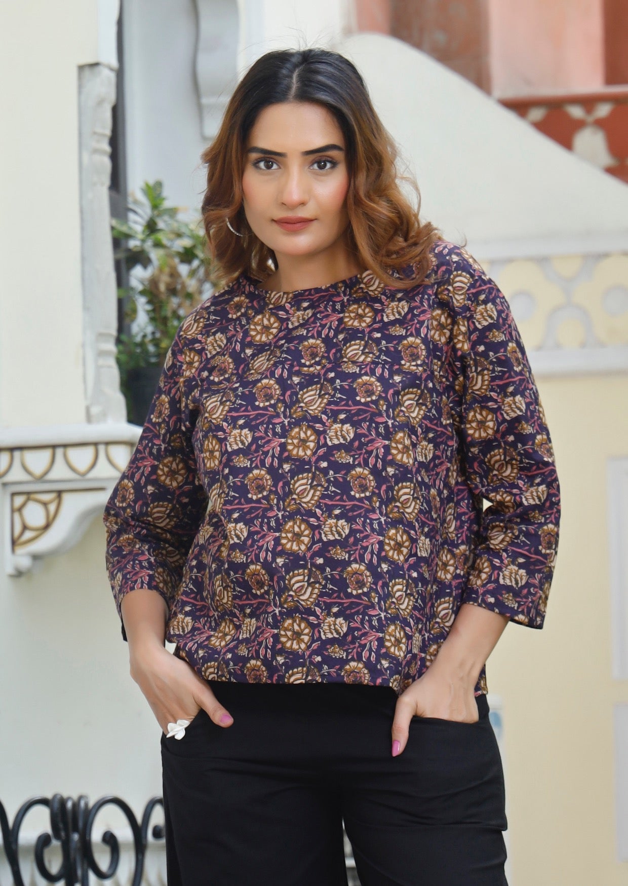 Model wears relaxed fit cotton top with 3/4 sleeves and round neckline in dark purple based floral print.