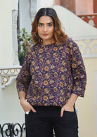 Model wears relaxed fit cotton top with 3/4 sleeves and round neckline in dark purple based floral print.