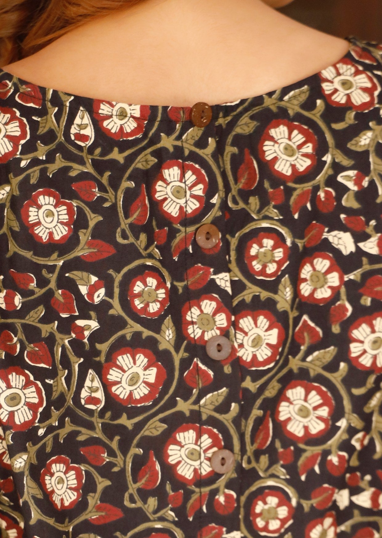 Model wears a relaxed-fit cotton top in a beautiful floral print, finished with decorative buttons down the back.