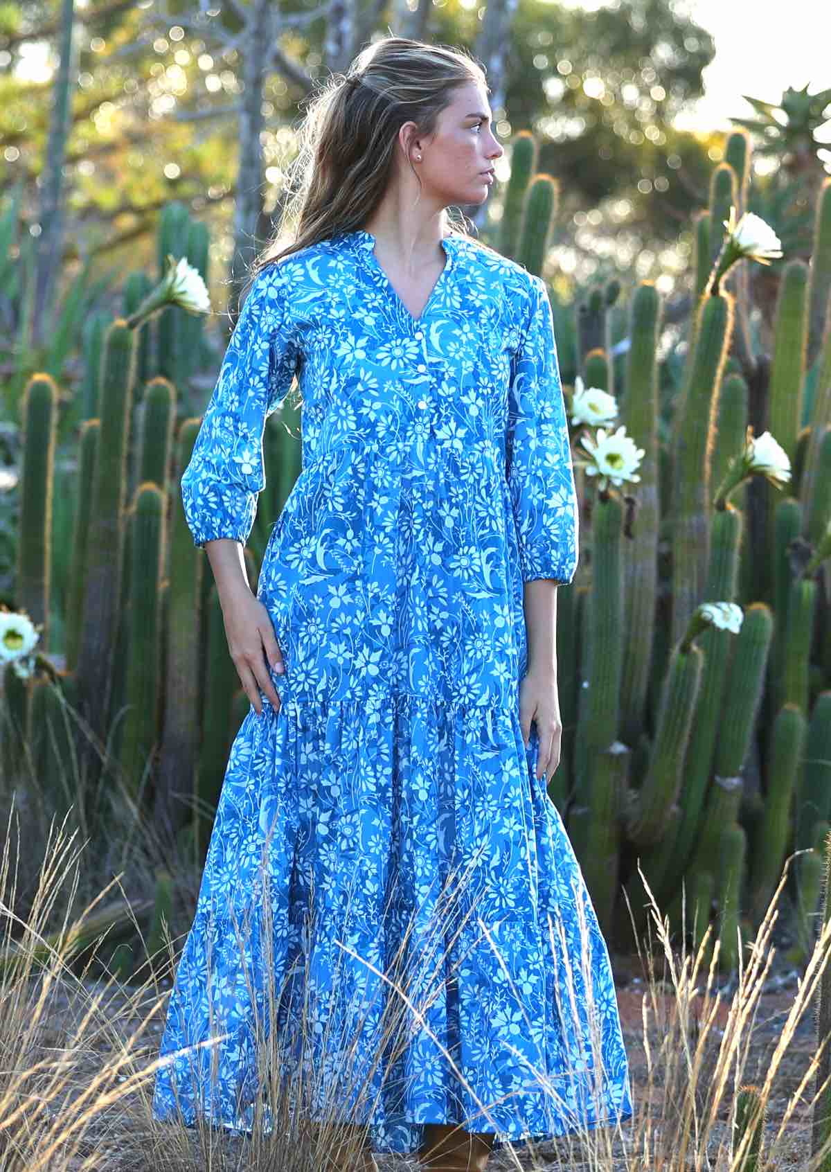 woman in blue cotton maxi dress with light blue and white floral print with pockets and long sleeves