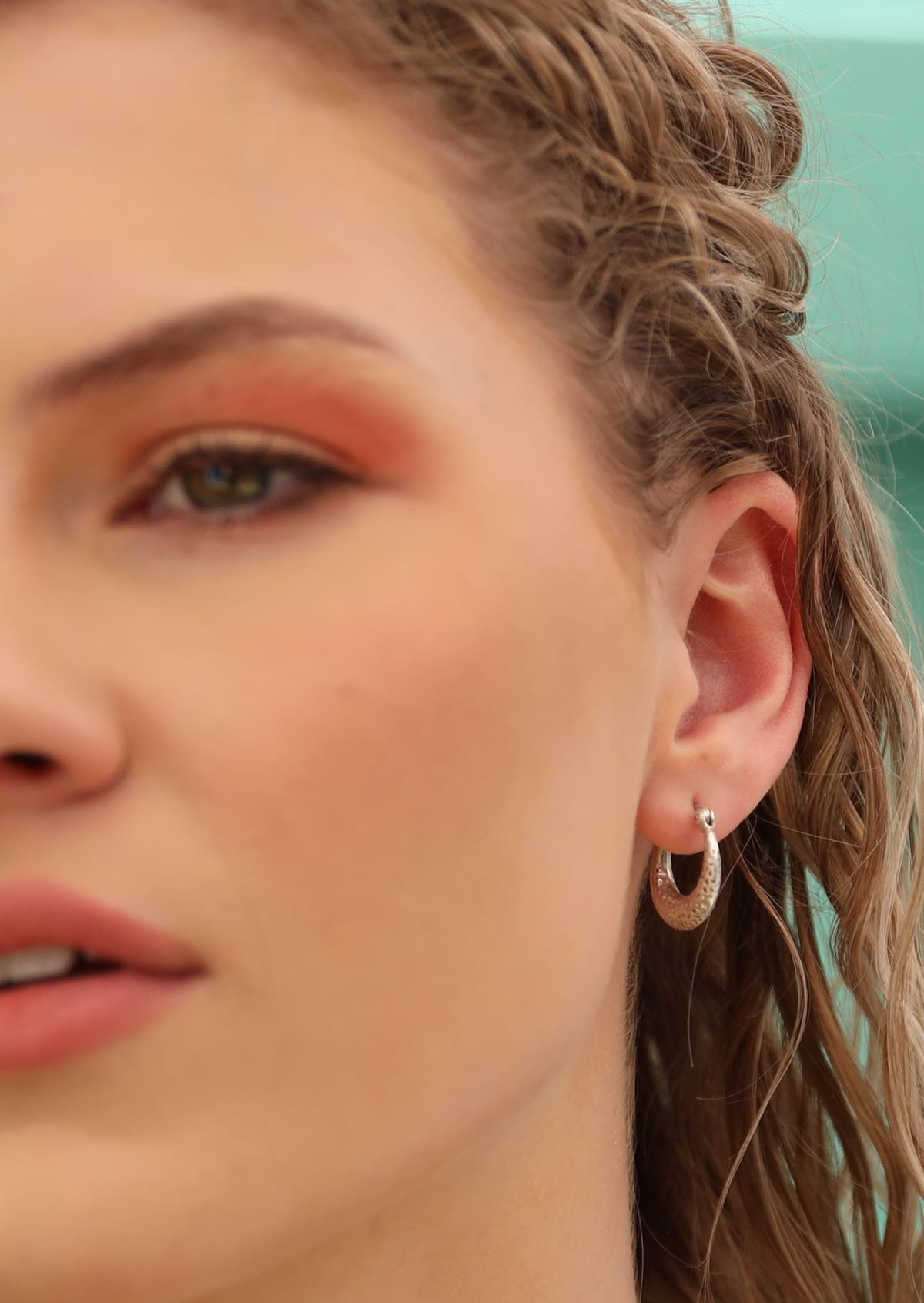 blonde haired woman wearing hammered silver hoops