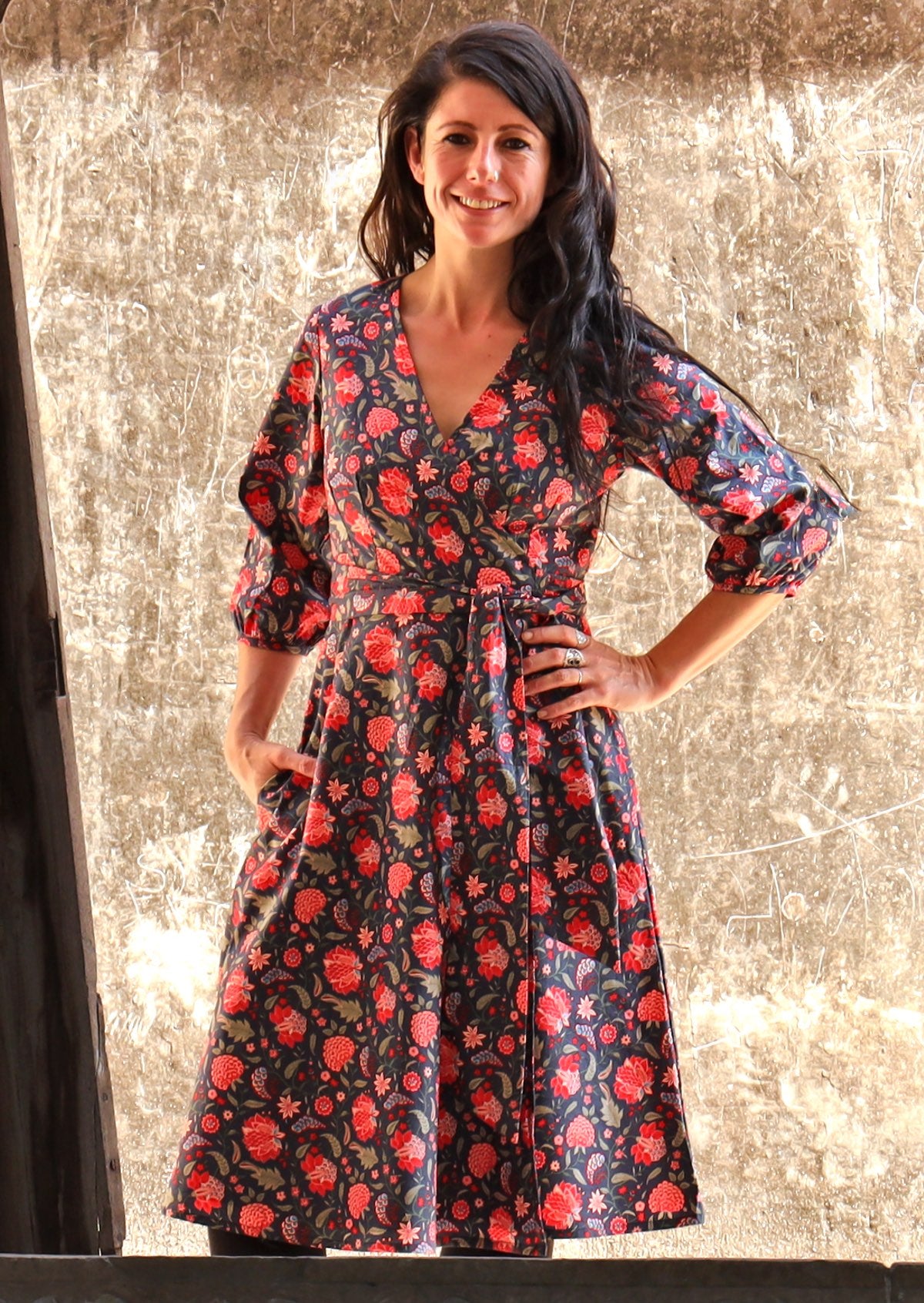 Model wearing floral printed cotton wrap dress with V neckline, 3/4 sleeves and pockets.