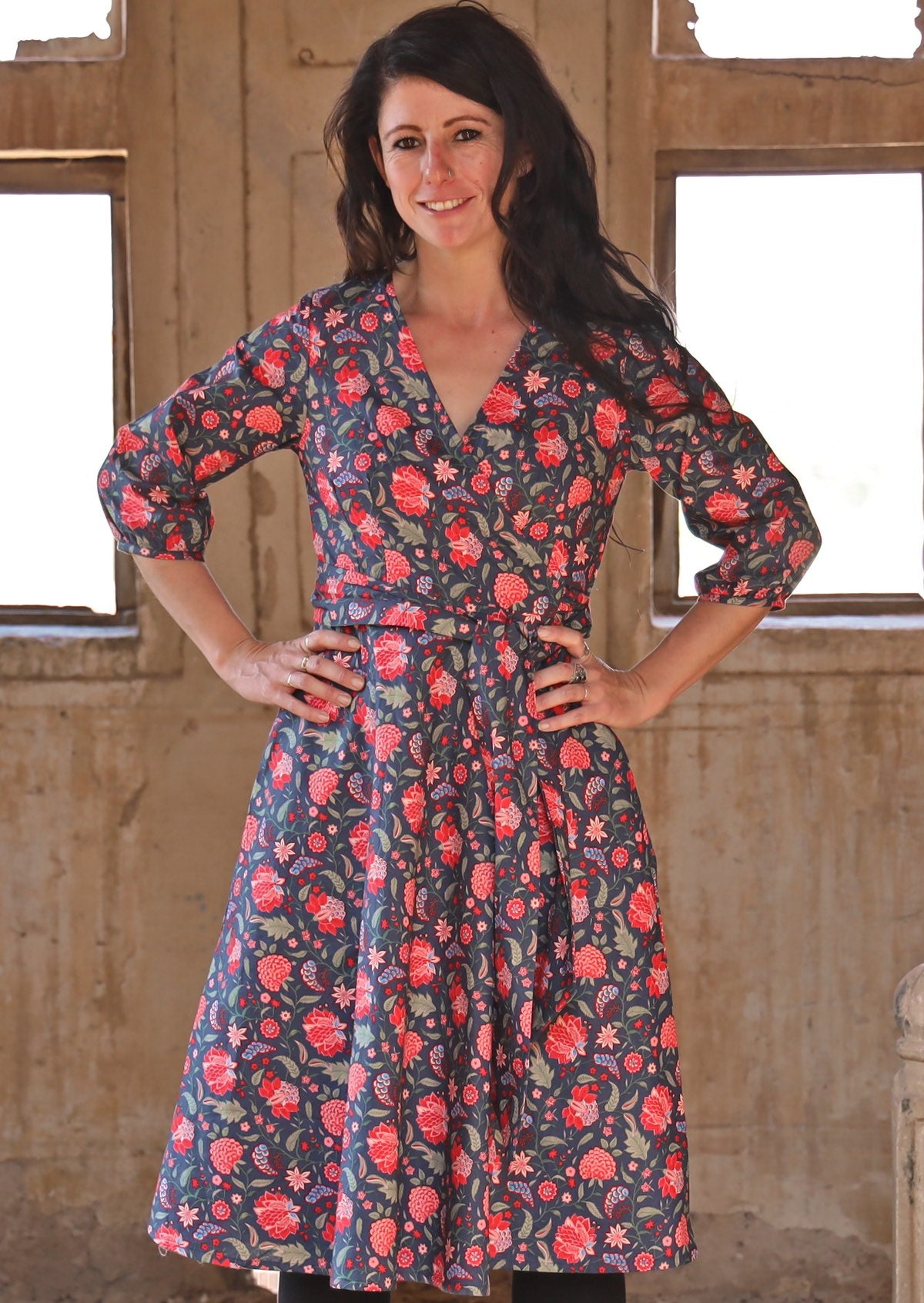 Front pose of model wearing cotton wrap dress with 3/4 sleeves and a flowing skirt style.