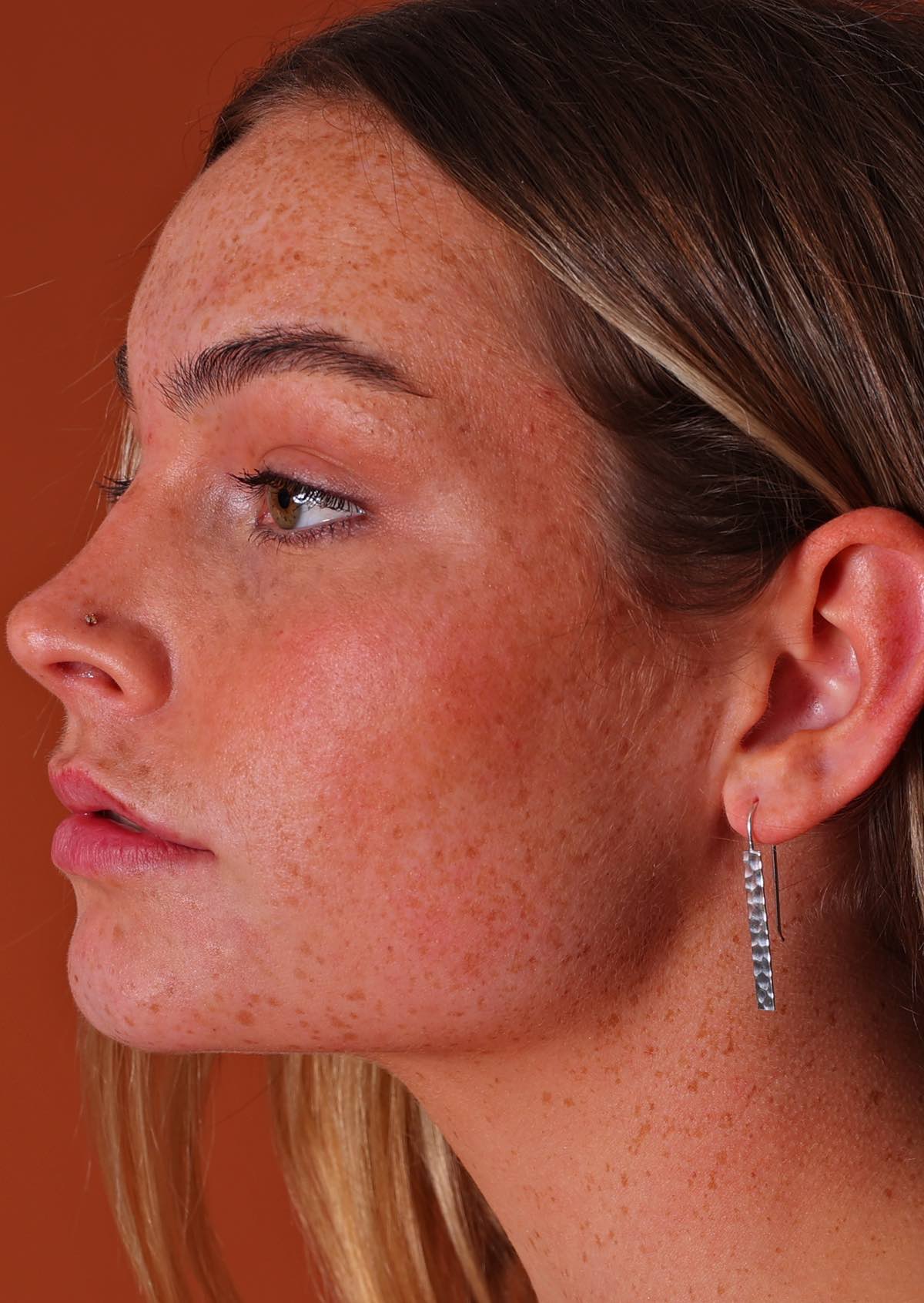 woman wearing modern hammered silver earring