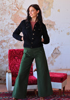 woman wearing black corduroy jacket and green corduroy pants