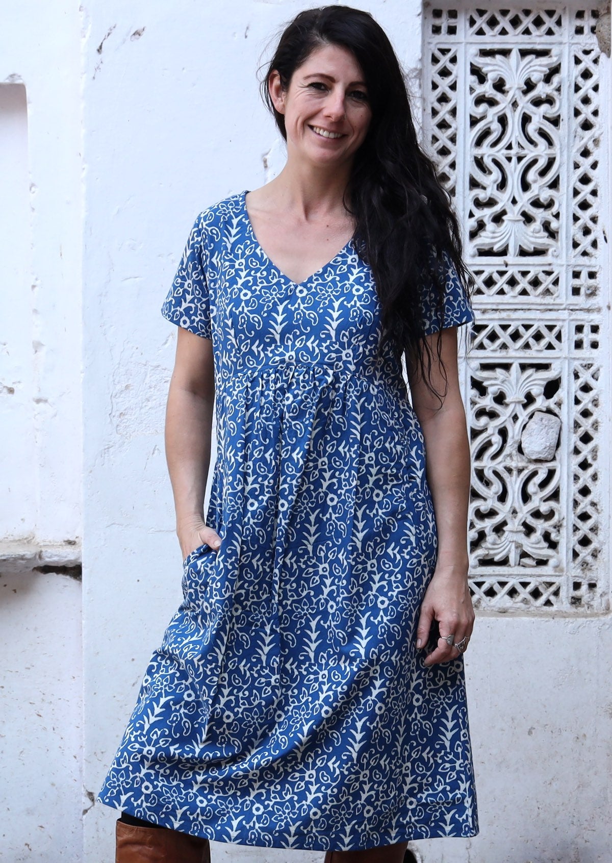 Model poses in cotton V-neck short sleeve dress with hand in pocket