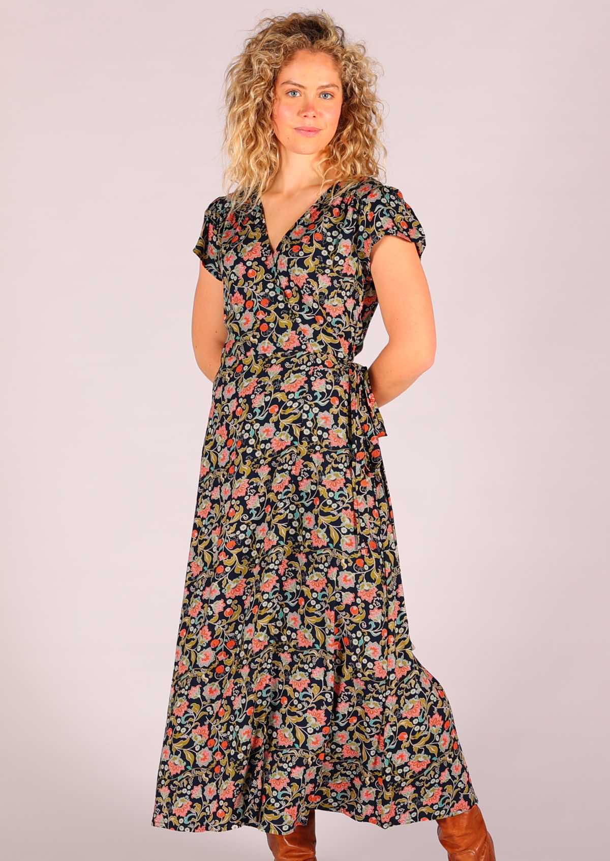 Model standing with hands behind back wearing navy floral rayon wrap maxi sundress