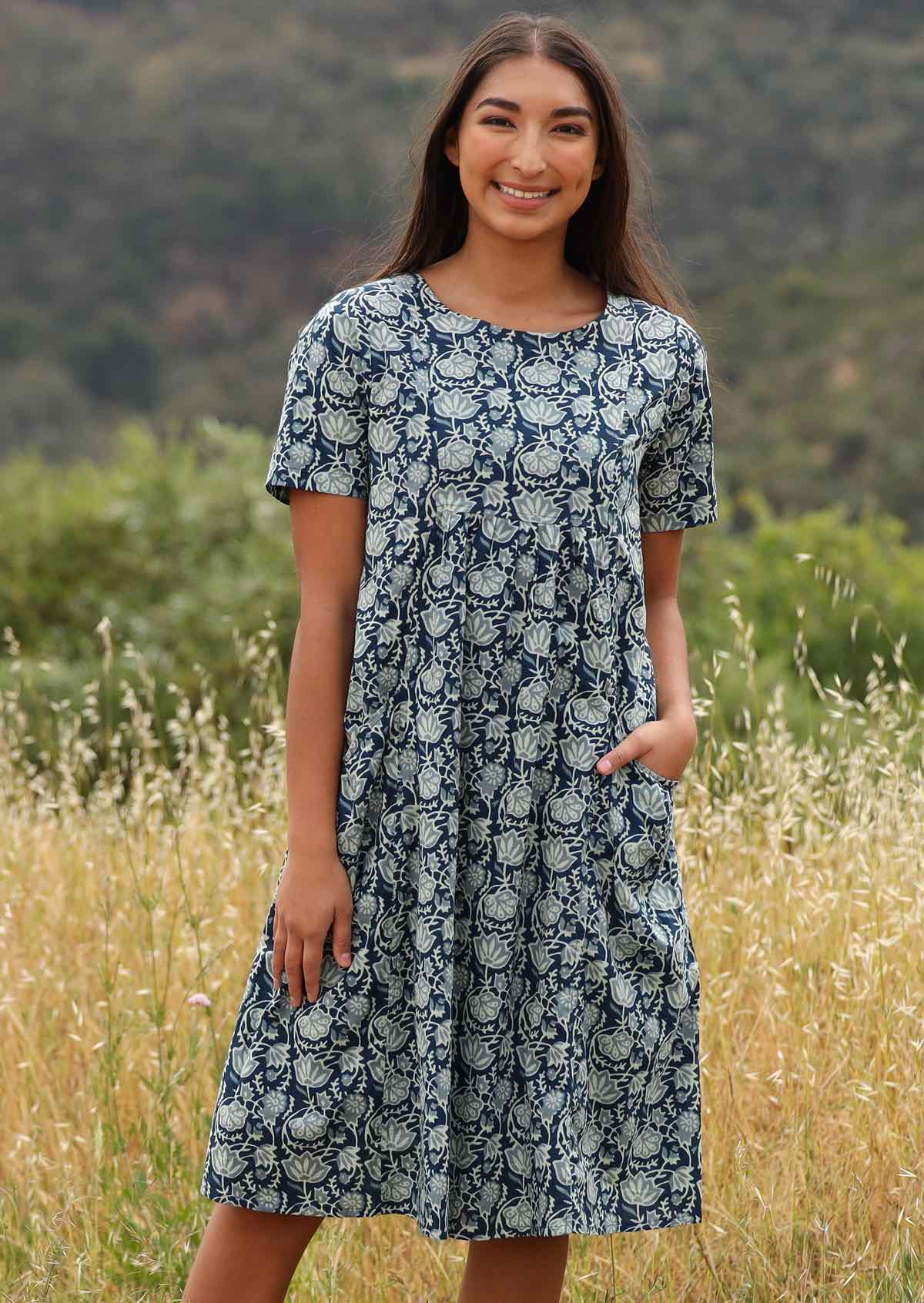 Woman wears knee length dress with a round neckline.