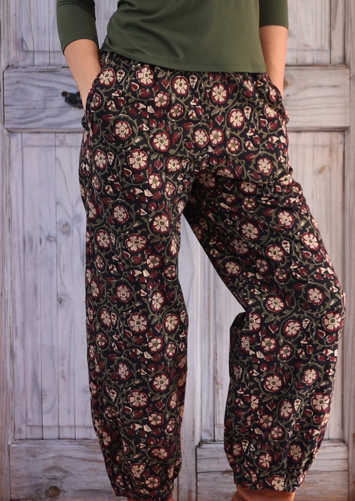 close up of hands in pockets in black based floral Indian 100% cotton pants