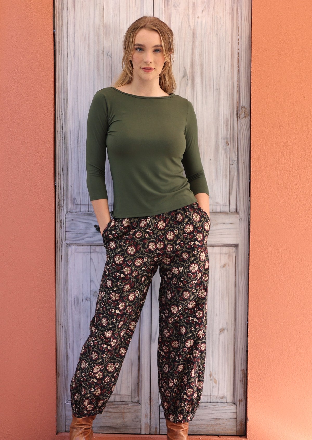 Woman standing with hands in pockets wearing black and floral 100% cotton pants