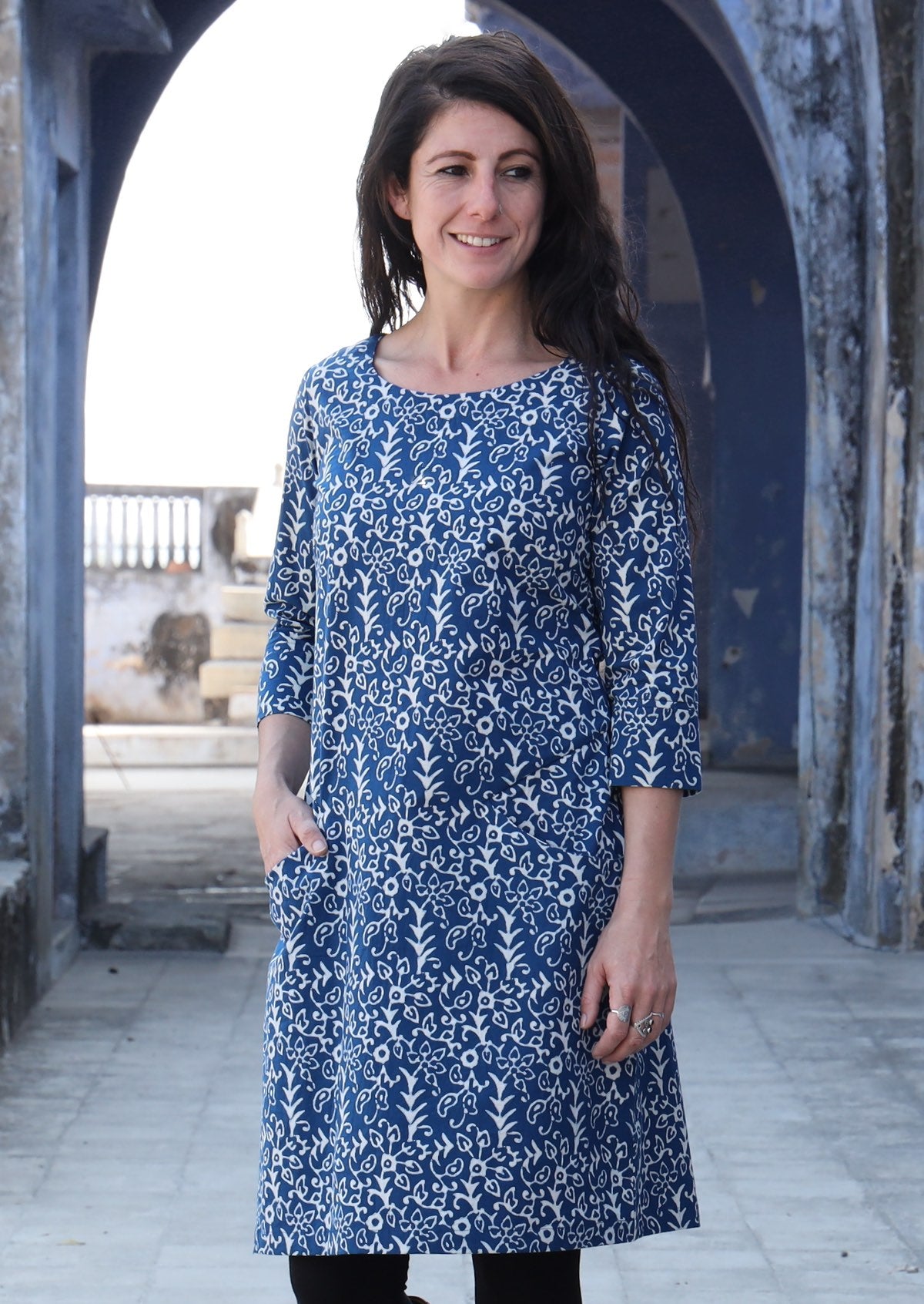 Woman standing with one hand in pocket wearing 100% cotton blue and white dress
