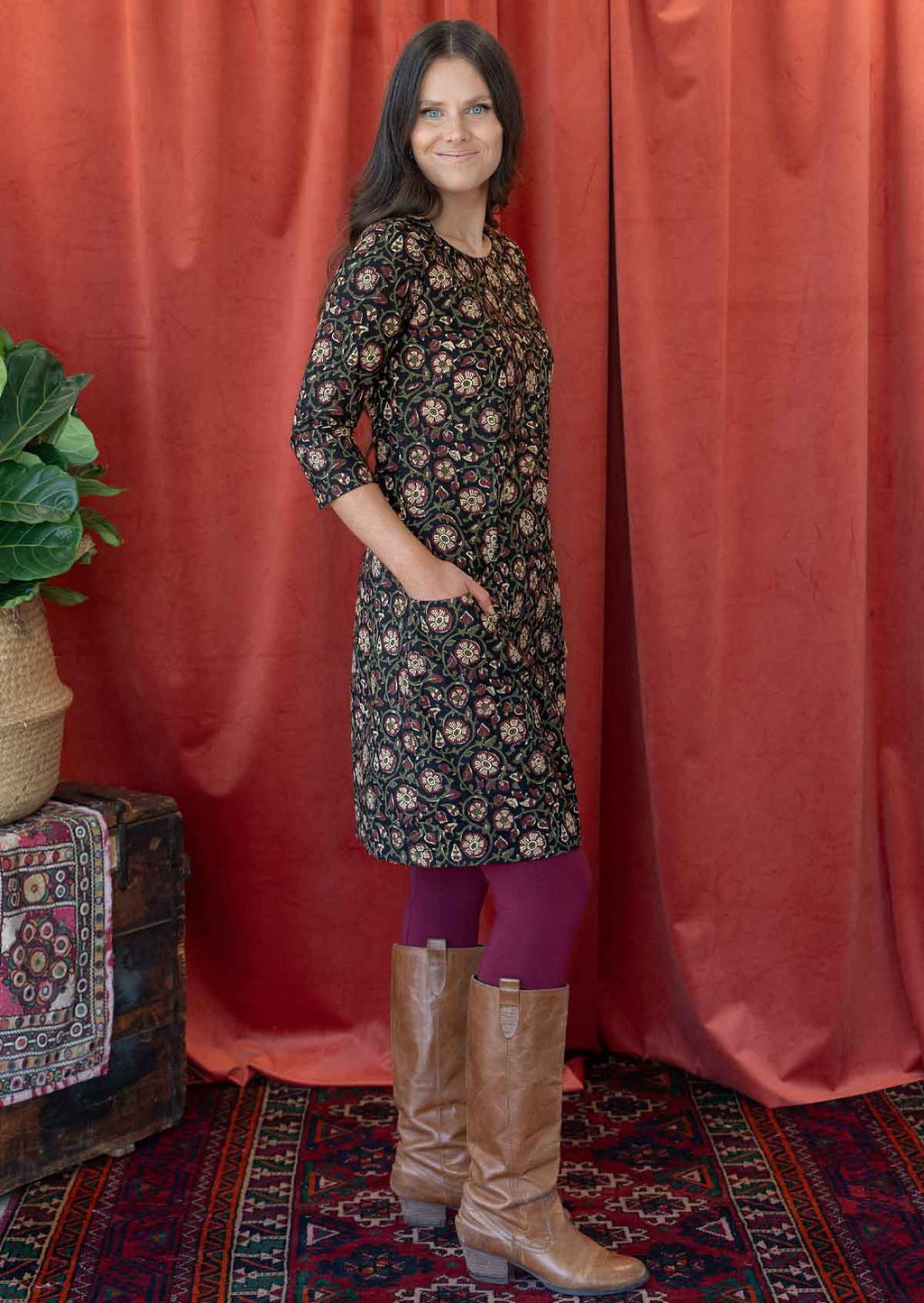 Woman wears knee length, floral printed cotton dress with 3/4 sleeves and pockets.