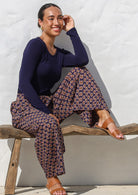 Woman in a sitting pose wearing a 100% cotton wide leg pants in delicate floral print with pockets and elastic at back.