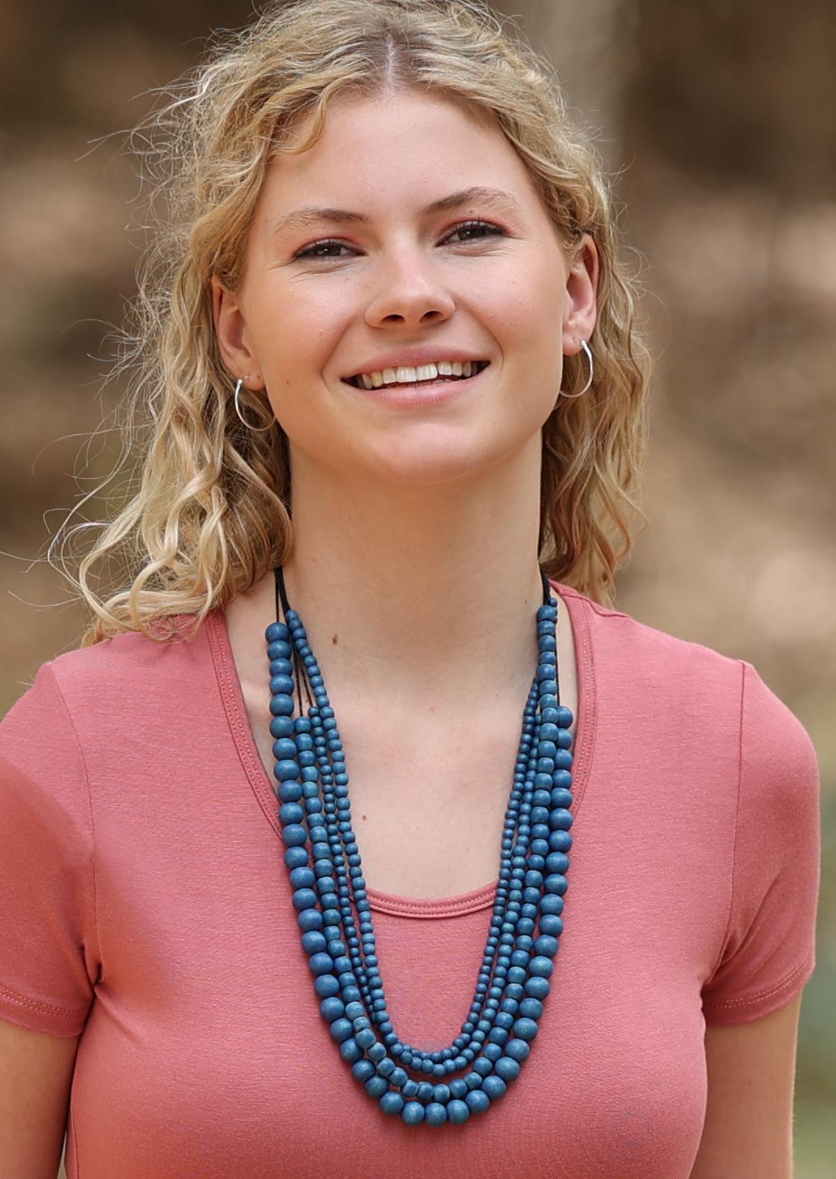 Four strands of different sized blue wooden beads