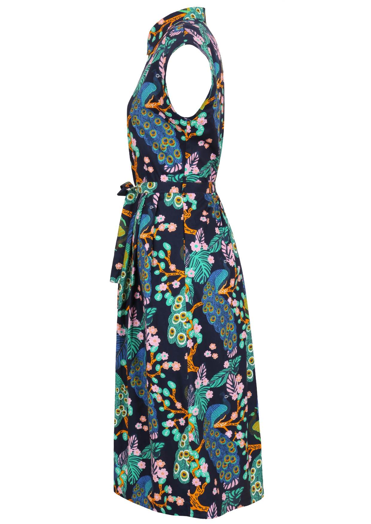 Side view of cap-sleeve button bodice cotton dress with a waist tie, collar and hidden side pockets, in a peacock and floral print on a dark navy base