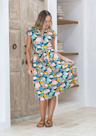 Woman wearing a pastel print cotton day dress with a waist tie and buttoned bodice | Katie Dress Sweet Spot