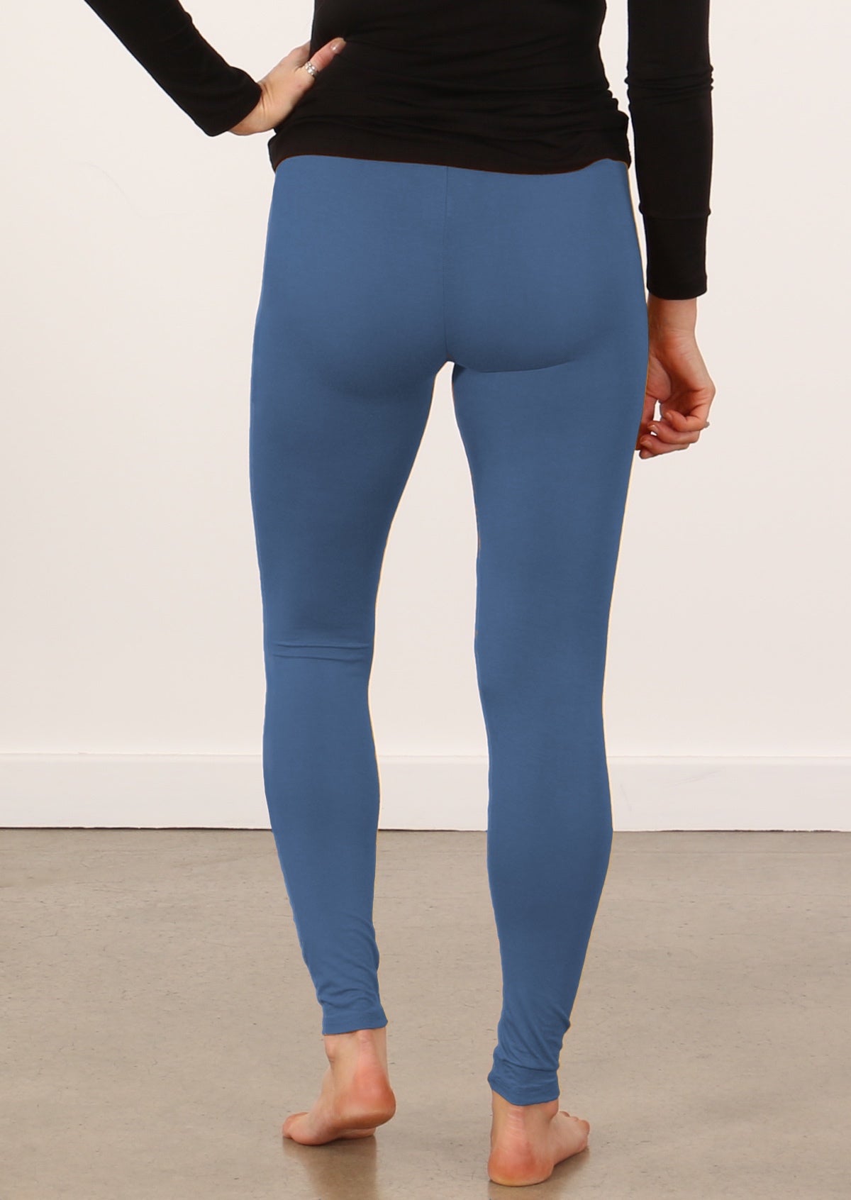 Person wearing blue soft stretch rayon leggings and a black top