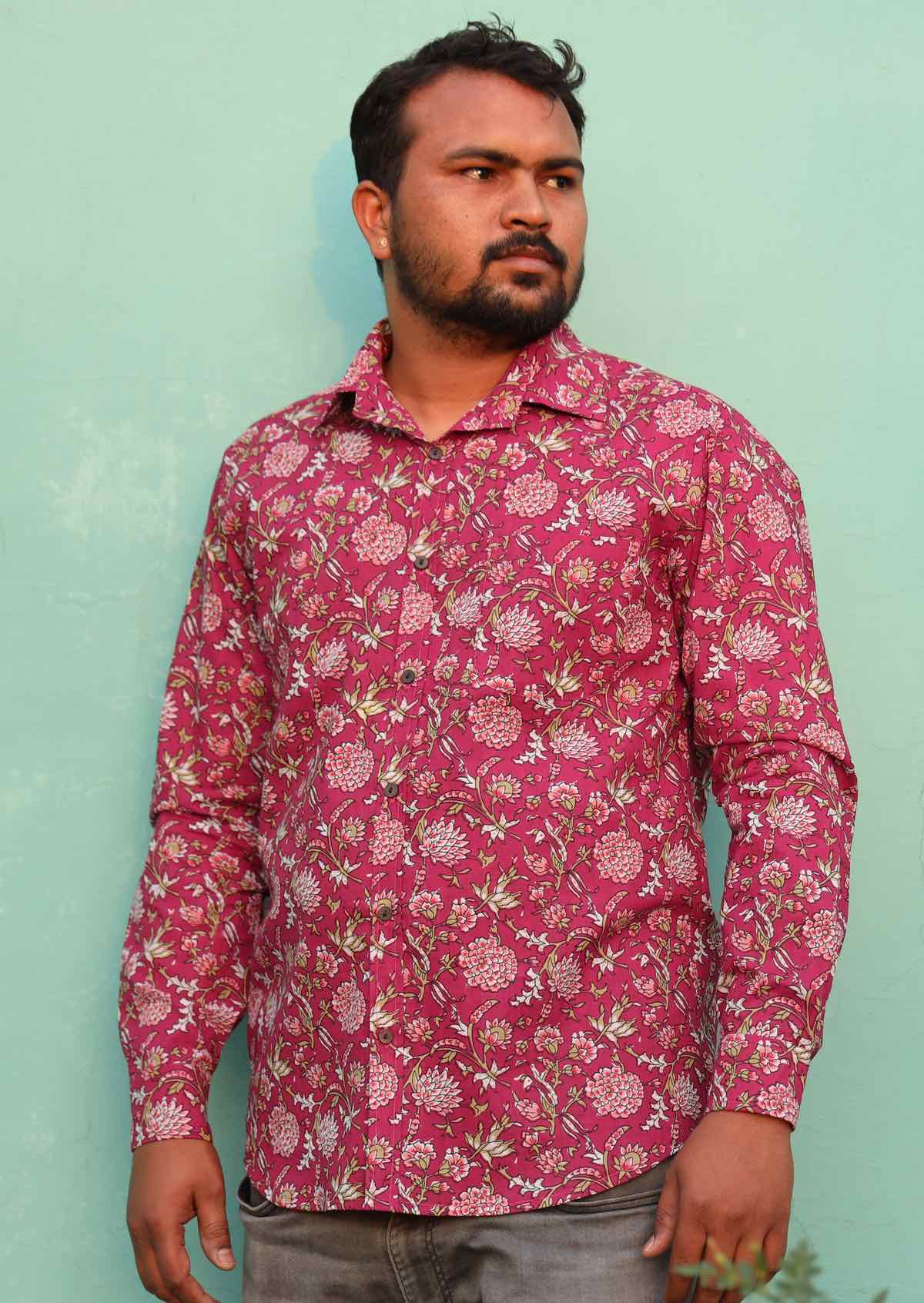 Man wears cotton long sleeve Indian floral print shirt with coconut buttons and a collar