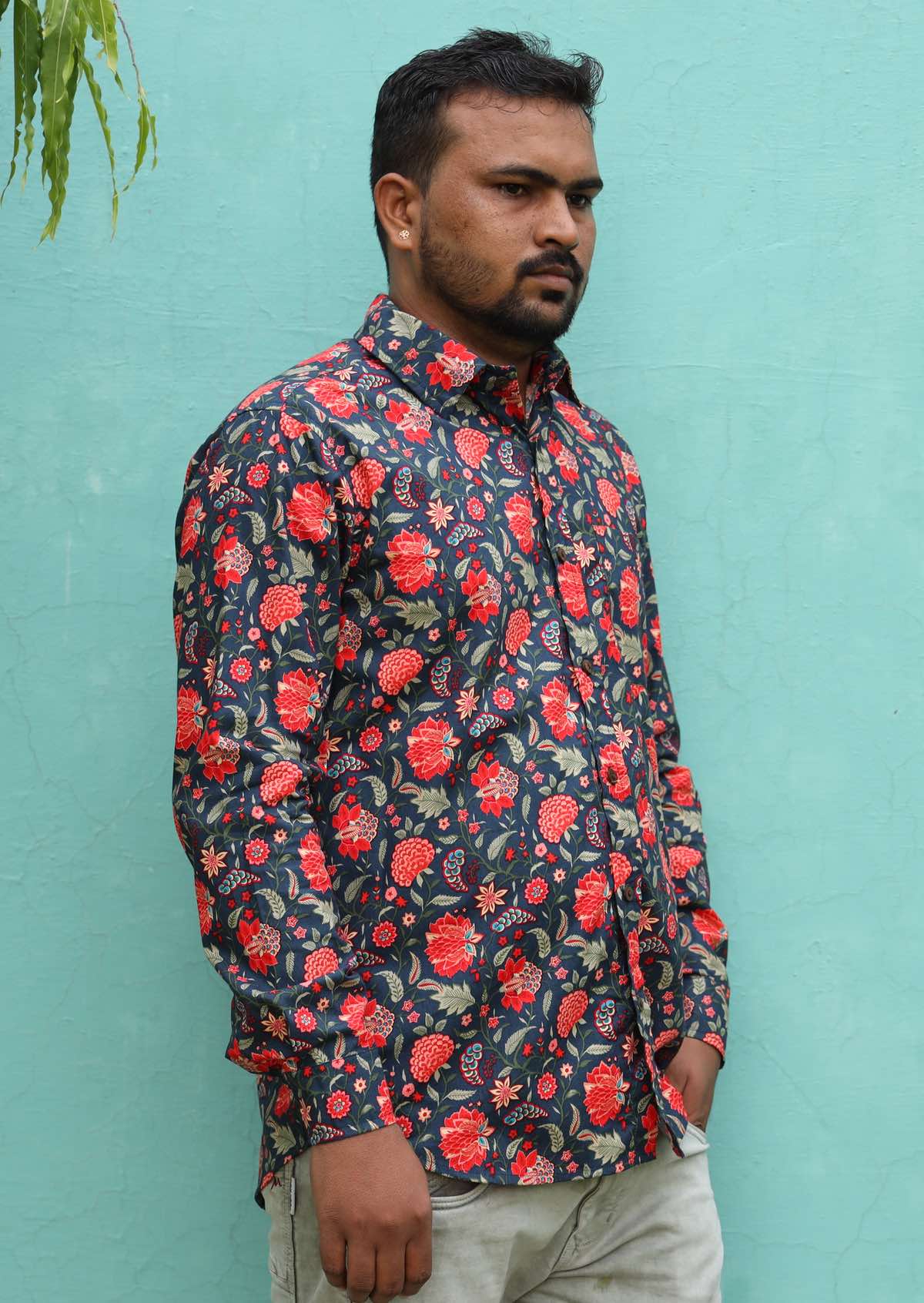 Man wearing a red and blue floral print collared shirt with long sleeves